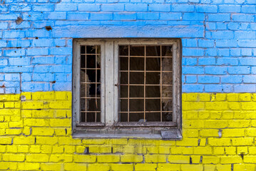 pattern explosion damaged blue yellow house wall with window in Ukraine