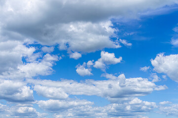 Breathtaking scene of the bright blue sky adorned with fluffy cumulus clouds, capturing the beauty...
