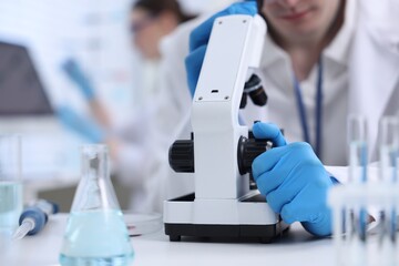 Scientist working with microscope in laboratory, closeup