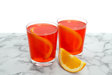 Aperol spritz cocktail and orange slices in glasses on marble table against white background