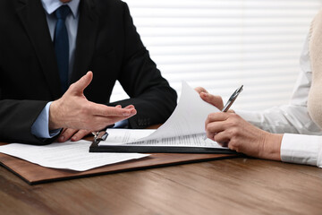 Senior woman signing document in lawyer's office, closeup
