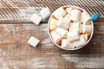Tasty hot chocolate with marshmallows on wooden table, top view. Space for text