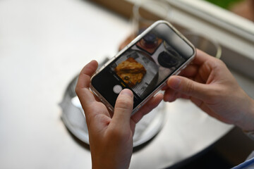 Close-up man photographing breakfast in a cafe with a smartphone, copy space