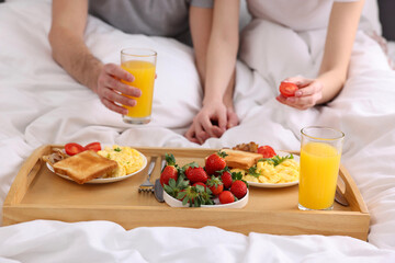 Obraz na płótnie Canvas Couple eating tasty breakfast in bed, closeup