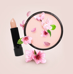 Spring flowers and makeup products in air on beige background