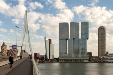 De Rotterdam Skyscraper designed by Rem Koolhaas architect and Erasmusbrug bridge against sky. Contemporary architecture.
