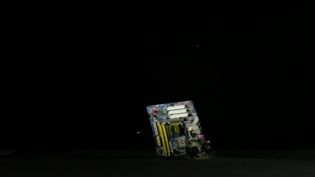 Male hands destroying and damaging computer motherboard, smashing it hard on the floor, slow motion shot. Technology and people concepts.