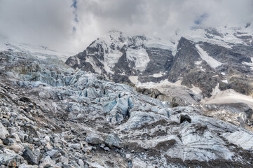 A melting glacier at the foot of a high mountain is sliding down.