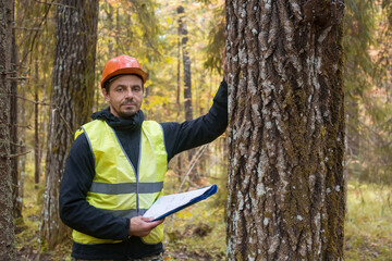 A 45-year-old man, an ecologist, works in the forest.