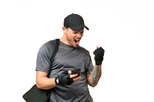 Young sport man with sport bag over isolated chroma key background with phone in victory position