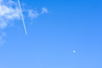 澄んだ青空と美しい飛行機雲と月