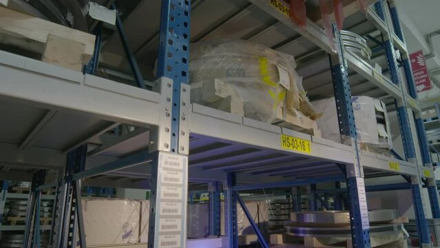 Forklift working in warehouse placing material on shelf