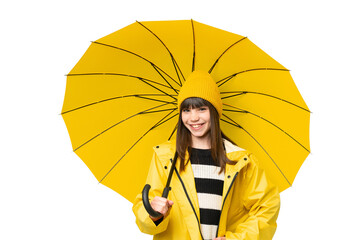 Little girl with rainproof coat and umbrella over isolated chroma key background posing with arms...
