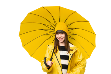 Little girl with rainproof coat and umbrella over isolated chroma key background posing with arms at hip and smiling