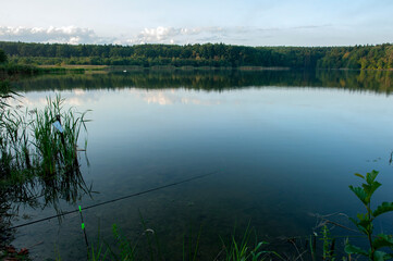 fisherman with fishing rods at sunrise on the lake