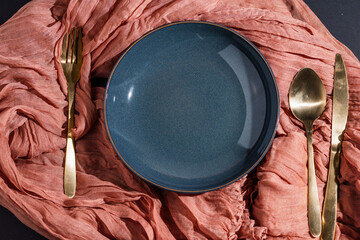 empty plate with cutlery on orange fabric, tableware prepared for meal