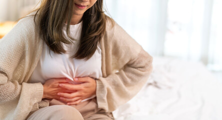 Woman sick unhappy holding belly stomach with suffering from stomach ache pain, monthly period,...
