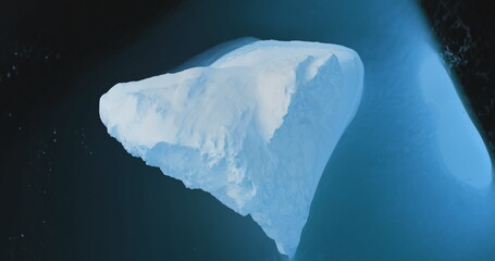 Huge iceberg in blue water aerial top down view. A breathtaking scene of Antarctic big glacier in...