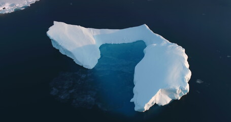 Melting Arctic iceberg aerial view. Glacier float in ocean water. Climate change and global warming...