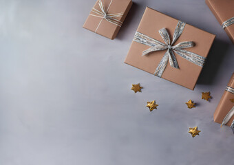  Brown gift box and white ribbon on gray background.