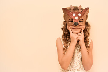 Unique child. Happy child in deer costume. Little cute girl in a carnival masquerade deer mask made of foamiran. The child is preparing to celebrate festival.