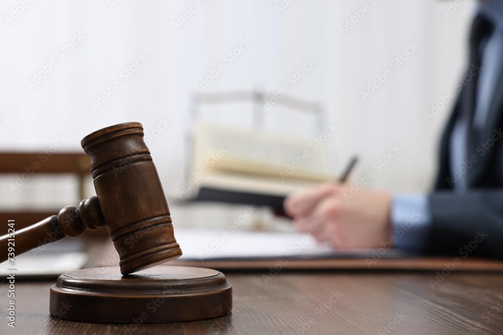 Sticker Lawyer working with documents at wooden table, focus on gavel