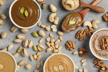 Tasty nut butters and raw nuts on light grey table, flat lay