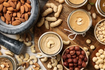 Making nut butters from different nuts, flat lay composition on wooden table