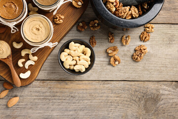 Making nut butters from different nuts. Fat lay composition with space for text on wooden table