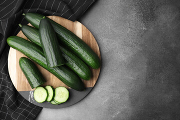 Fresh cucumbers on grey textured table, top view. Space for text