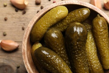Tasty pickled cucumbers in bowl on table, top view