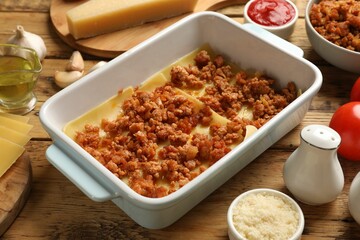 Cooking lasagna. Pasta sheets and minced meat in baking tray on wooden table, closeup