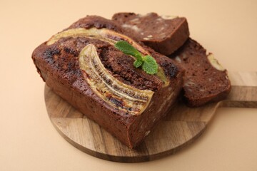 Delicious banana bread with mint on beige background, closeup