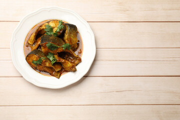 Tasty fish curry on white wooden table, top view. Space for text. Indian cuisine