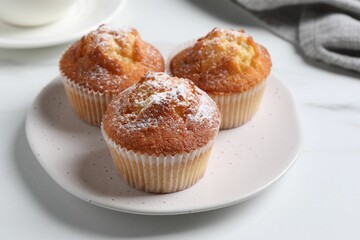 Delicious sweet muffins on white marble table, closeup
