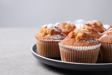 Delicious sweet muffins on light grey textured table, closeup. Space for text