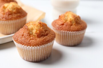 Delicious sweet muffins on white table, closeup. Space for text