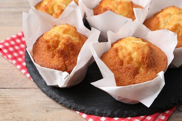 Delicious sweet muffins on wooden table, closeup