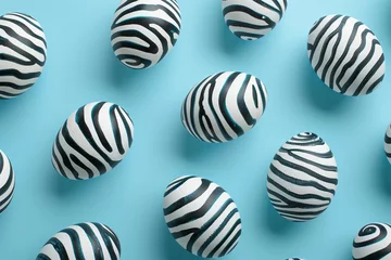 Foto op Canvas  zebra pattern eggs on pastel blue background.  © ALL YOU NEED studio