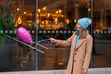 happy asian woman with a heart-shaped balloon falling a love, having a fun day, walking around  an...