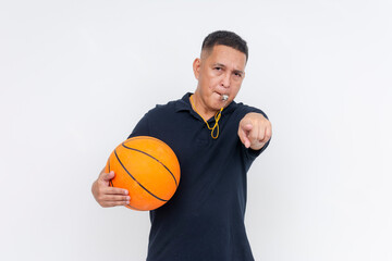An irate middle-aged basketball coach or referee in casual attire holding a ball blowing a whistle,...
