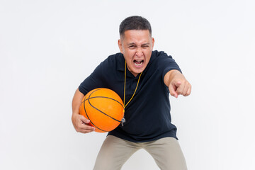 An irate middle-aged basketball coach in casual attire holding on the sidelines shouting and berating someone, pointing with his finger. Holding a basketball. Isolated on a white background.