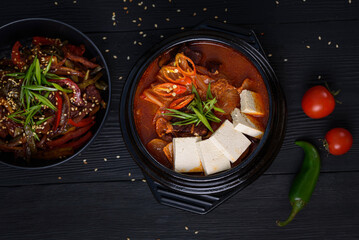Korean food. Traditional Kimchi soup. on a black wooden background.