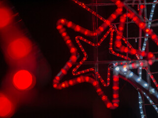 christmas background with red star on dark bokeh defocused lights