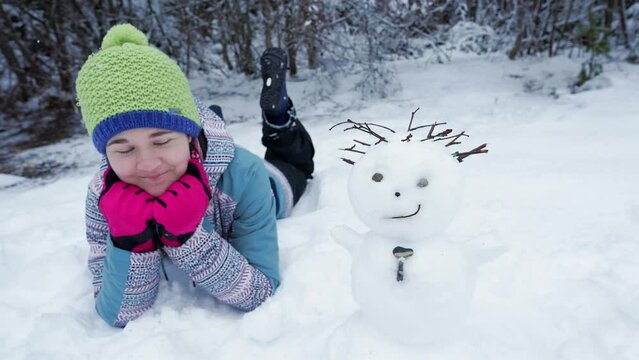 M&auml;dchen zwinkert Schneemann zu