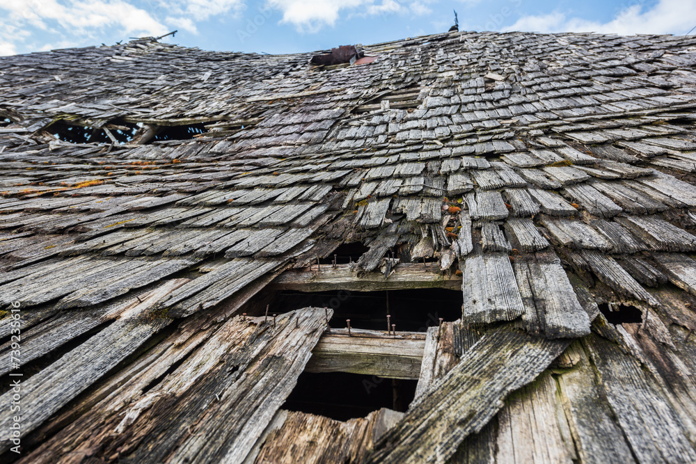 Wall mural Close up, an old abandoned traditional wooden building in Romania mountain village, falling apart from the effects of atmospheric precipitation. Shallow depth of field.