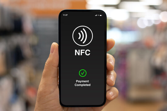 Male hand phone pay wireless technology nfc via pos terminal.