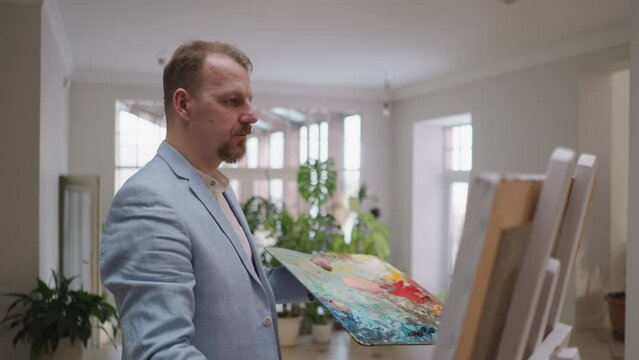 Man takes art lesson at easel in studio