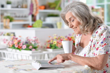 Beautiful senior woman using tablet at home
