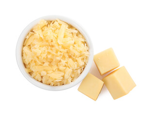 Grated cheese in bowl and pieces of one isolated on white, top view